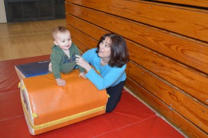 Nika Prather demonstrates Romp and Roll with Bryson Tolson, age 1 1/2, at the North Webster Community Center. Romp and Roll is a program introducing toddlers and preschoolers to a variety of movement concepts.