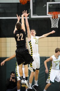 Chase Myers of Wawasee contests the jump shot of Columbia City's Justin Bachelder Saturday night. (Photos by Mike Deak)