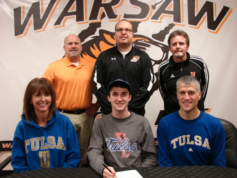 WCHS senior Ellis Coon signs Thursday to continue his track and cross country career at Tulsa University. Coon is surrounded by his parents Christine and Michael. In back are WCHS Athletic Director Dave Anson, WCHS track and cross country assistant coach Rob Peters and WCHS cross country head coach Jim Mills (Photo provided)