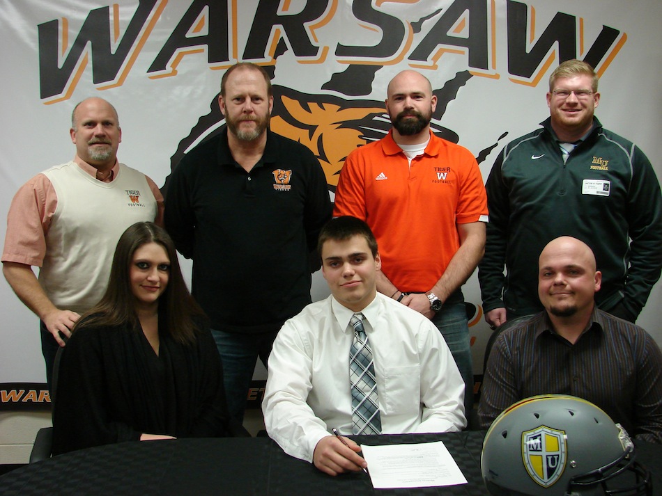 WCHS star tailback Tristan McClone signed Friday  to play football at Marian University. McClone is flanked by his parents Carrie and Dustin.  In back are WCHS Athletic Director Dave Anson, WCHS football coach Phil Jensen, WCHS defensive coordinator Kris Hueber and Marian assistant coach Jacob Topp (Photo provided)