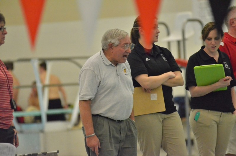 Viking head coach Buddy Busby encourages Tanner Neeley during the 100 backstroke on Thursday night. 