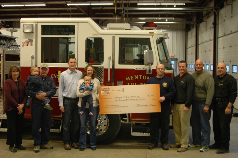 From left are Sandy Wise, Andrew Wise, Jim Wise, Jeff Wise, Melissa Wise, Makenzie Wise, Mentone Fire Chief Mike Yazel, Daniel Stauffer of Specialty Hybrids, Mentone Fire Department Assistant Chiefs Doug Miller and  Jim Eads. MFD plans to use the money to purchase a grain rescue tube. "It gives us another rescue tool that we don't have now," said Yazel. (Photo by John Faulkner) 