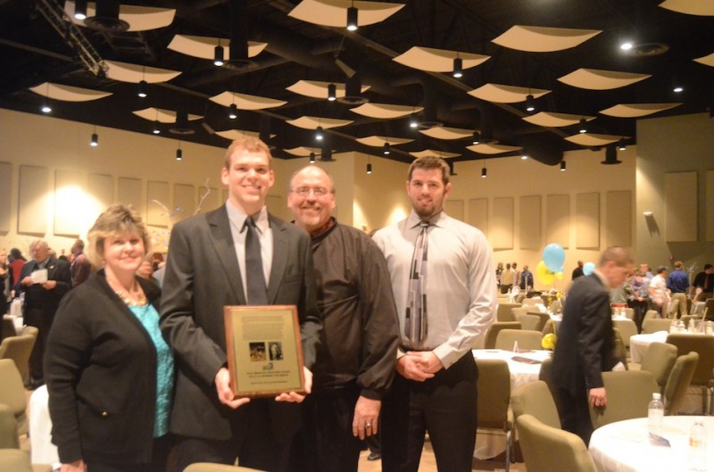 Grace College senior Greg Miller is shown with his parents Mike and Debbie and older brother Adam after receiving the Pete Maravich Award at the NCCAA Championships Banquet Tuesday night in Warsaw.