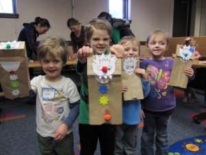 The Syracuse Library is trying to get rid of winter with some snow-muncher puppets. Pictured (from left) is: Liam, Grayson Lashley and Xander and Natalie Miller. The groups have been melting away the grumpies and fears and look forward to special times with rabbits, butterflies and flowers. Each week the children add another bug to the bulletin board where each face has become a blooming flower. (Photo provided)