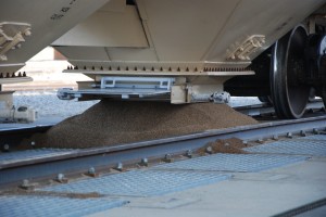 Crop nutrients from a train car flow into an underground pit, where a conveyer belt takes product to the hub for storage and distribution.