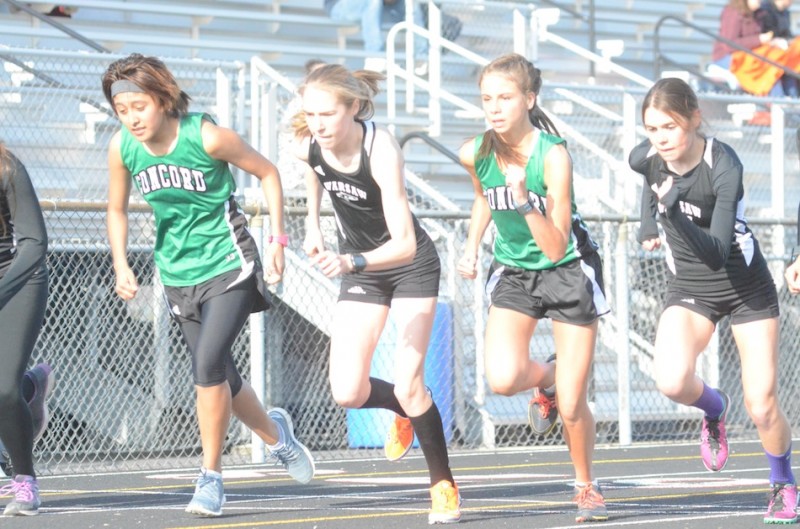 Allison Miller and Brooke Rhodes of Warsaw break from the finish line to start the 1,600 Wednesday night at NorthWood. Miller placed first and Rhodes second in the event as the Tigers defeated NorthWood and Concord in NLC action.