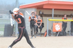 Kaleigh Speicher pops one up as her Warsaw teammates look on from the Tiger dugout. Speicher hit a two-run homer in a 3-1 win over Wawasee.