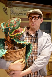 Seymore (Joe Ford) holds a growing Audrey II in one of the scenes from “Little Shop of Horrors” now on stage until May 25 at Amish Acres Round Barn Theatre. For reservations or information call the box office at (800) 800-4942 or online at amishacres.com