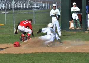 Rylan Kuhn (25) slides in safely at home plate in the third inning of Wawasee's win over Plymouth.