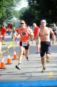 Andrew Saal, left, and John White race to the finish line at the 2013 Warsaw Optimist Triathlon. (File photo by Mike Deak)