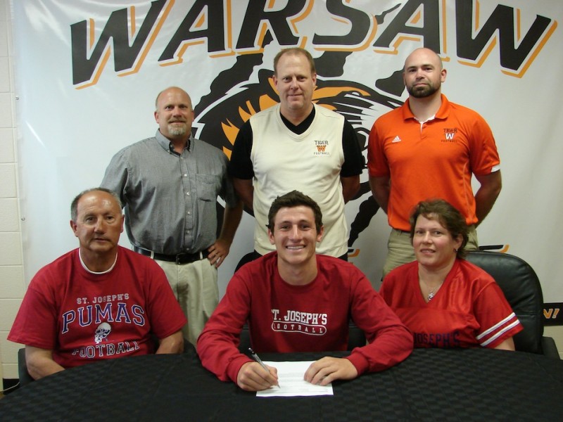 Warsaw senior Gabe Furnivall will play football at Saint Joseph's. Furnivall is shown seated above in the front row with his parents Troy and Kim.  In back are WCHS Athletic Director Dave Anson, head football coach Phil Jensen and defensive coordinator Kris Hueber (Photo provided)