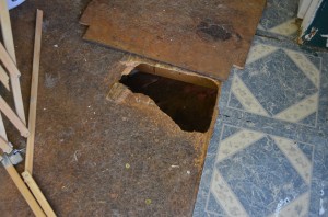 A mother and daughter are in desperate need of help. This hole in their trailer floor is where an opossum recently got inside. (Photo by Stacey Page)