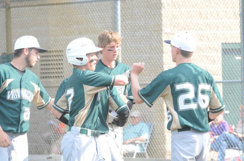 Drew Anderson is greeted by teammates after driving in a run for Wawasee Wednesday.  The Warriors rallied to top Warsaw 4-3.