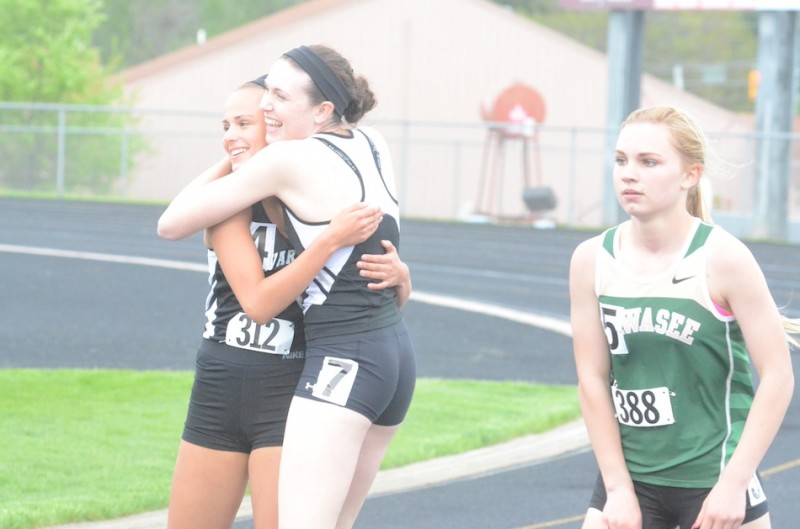 Warsaw senior Ann Harvuot gives teammate Mariah Harter a big hug after they placed 1-2 in the 100 Tuesday night at the NLC Meet.