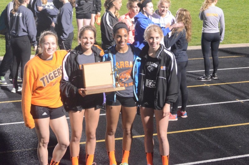 The Warsaw 4 X 400 relay team proudly shows off the NLC Meet trophy Tuesday night.