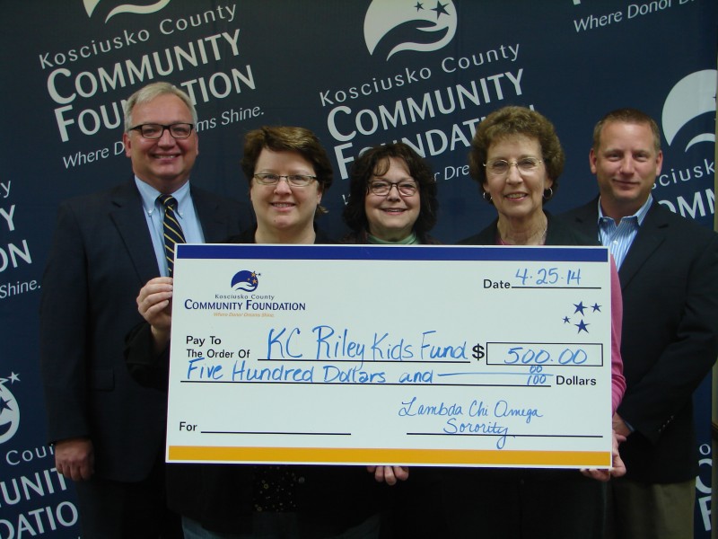 Lambda Chi Omega Sorority presents a $500 donation to the KC Riley Kids Fund. Pictured from left to right are Mike Bergen, fund founder; Laura Greig, sorority President; Suzie Light, Kosciusko County Community Foundation; Sue Bradway, sorority member; and Woody Zimmerman, Lake City Radio, host of Riley Radio Days.