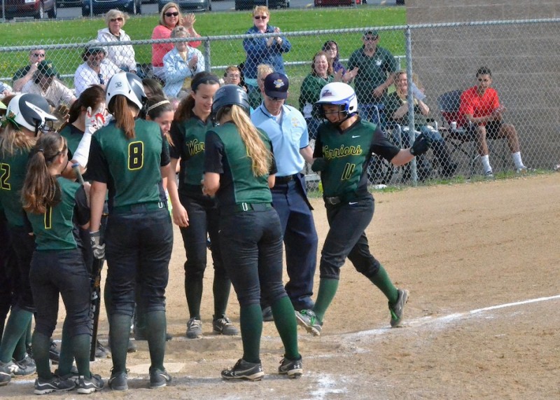 Danielle Gunkel is greeted at home plate by her teammates after her home run in the bottom of the first inning.