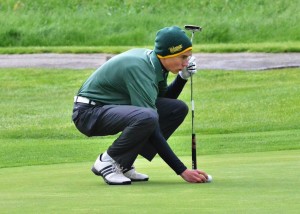 Senior Rasmus Rich sizes up his put on the fifth green in his final home match.