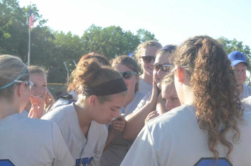 An emotional Mallorie Jennings is surrounded by her teammates Tuesday night. Jennings pitched the Trojans to the first regional championship in program history.