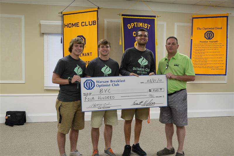 (From left) Ryan and Chad Goon and Nikos Schlitt, representing the Octagon Club, present the check to Tracy Furnivall, representing Baker Youth Club. (Photo provided)