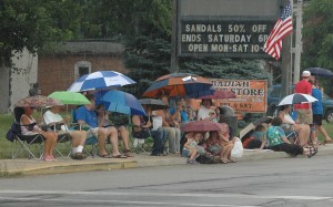 These umbrellas were not to protect parade viewers from the sun, but from a down burst of rain just before the parade's start. (Photo by Deb Patterson)