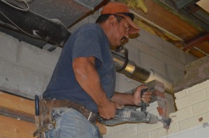 Ben Lopez of Robert E. Crosby Inc., Fort Wayne, uses a jackhammer to tear down a wall in the radio studio area of Wawasee High School. The studio is being renovated this summer.