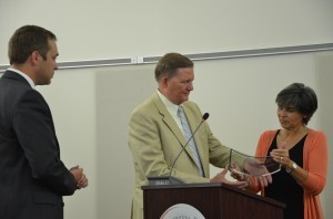 Dr. Craig Hintz (center) is awarded a district award by Dr. David Hoffert (left) and Board President Jennifer Tandy.  (Photo by Alyssa Richardson)