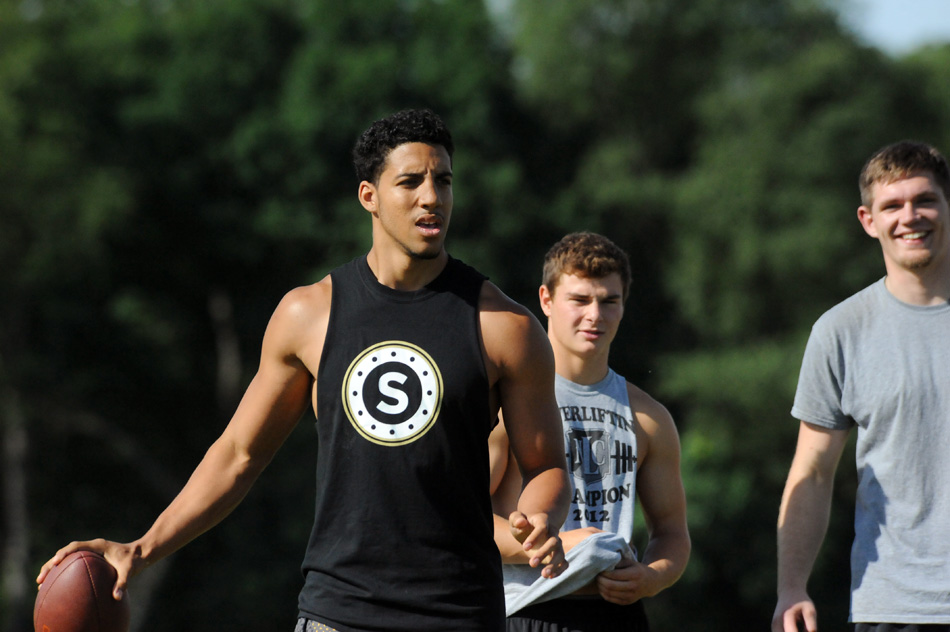 Zac Patrick sizes up the field ahead of his attempt in the football throwing competition as former Wawasee football teammates Brandin McCulloch and John Essex look on at the 2014 Tournament of Champions. (File photo by Mike Deak)