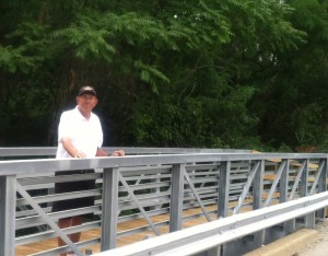 Bill Musser of the Syracuse Town Council stands on the new bridge over Harkless Drive.