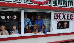 The hard working Dixie Day Committee of the North Webster-Tippecanoe Township Chamber of Commerce takes a brief break onboard the Dixie. From left to right, front row are Helen Leinbach, Jen Ducey, Kim Cantrell, Sue Ward, and Linda Land. In the window are Jeremy Likens and Karilyn Metcalf. In back are Chris Lusso, Ben Ashpole, Steve Ward, Richard Owen and Don Roulo. (Photo by Martha Stoelting) 