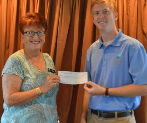 Kay Young, president of Wawasee Property Owners Association, present Dr. Nate Bosch, Center for Lakes and Streams, a check to support an aquarium at Syracuse Elementary. (Photo by Deb Patterson)