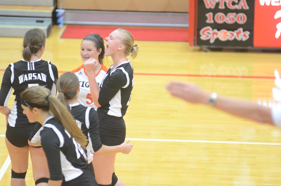 A fired-up Katie Voelz celebrates for Warsaw during a key NLC volleyball victory  at Plymouth Thursday night.
