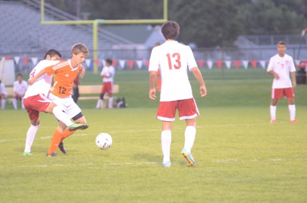Warsaw's Brad Ocock protects the ball versus host Goshen Thursday night. The No. 15 Redskins won 2-1.