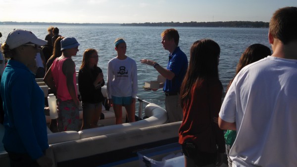 Dr. Nate Bosch, far right, director of the Center for Lakes and Streams at Grace College, addresses Wawasee High School honors biology students, from left, Cayden Wegener, Adrienne Gill and Kabrea Rostochak at Lake Wawasee.