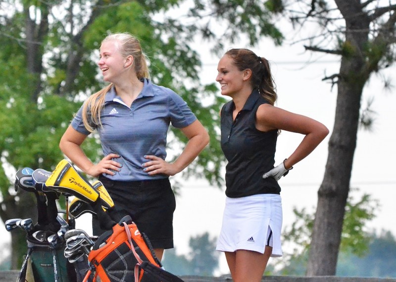 Wawasee's Kylee Rostochak (left) and Warsaw's Kristen Watson (right) share a laugh after teeing off on number seven. (Photos by Nick Goralczyk)