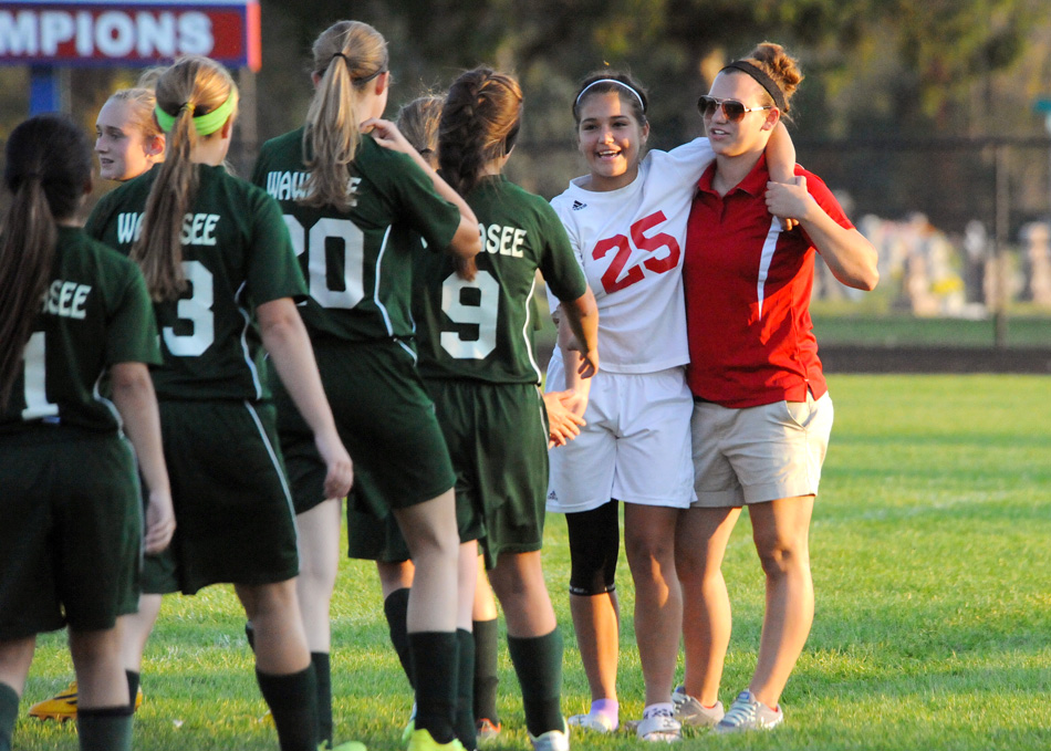 Whitko's Leighandra Goodman (25) is assisted by coach Christina Baughman while Wawasee players greet her following the match. Goodman injured her ankle in the second half and did not return.