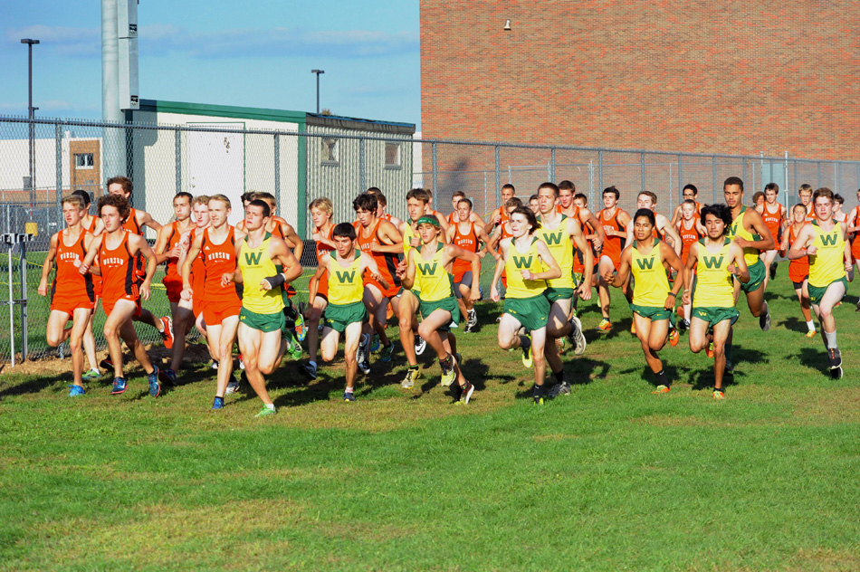 Members of the Warsaw and Wawasee boys cross country teams make a break at the start of the race Tuesday night at Wawasee.