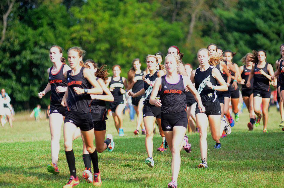 The Warsaw girls cross country team leads the pack at the start Tuesday night.