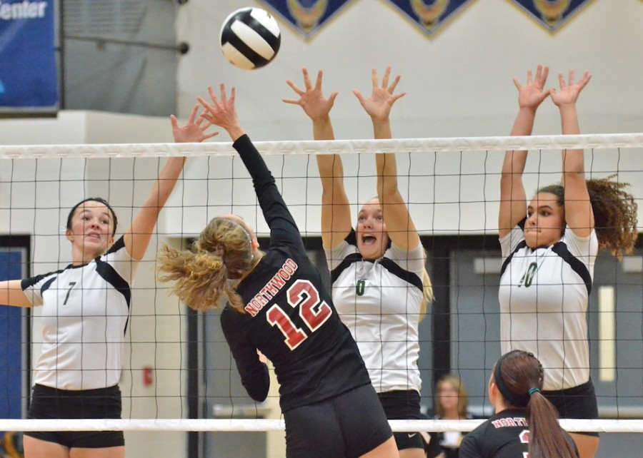 Alli Ousley (7), Meghan Fretz (6) and Seaquinn Bright (10) all go up for a block during the first game of Saturday's match.
