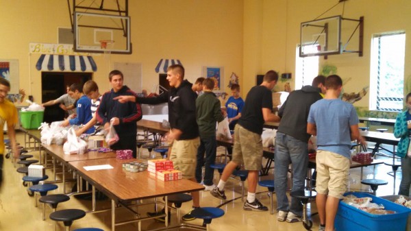 Pictured are members of the Triton boys' basketball team packing the food for the weekly distribution. The boys are coached by Jason Groves. 