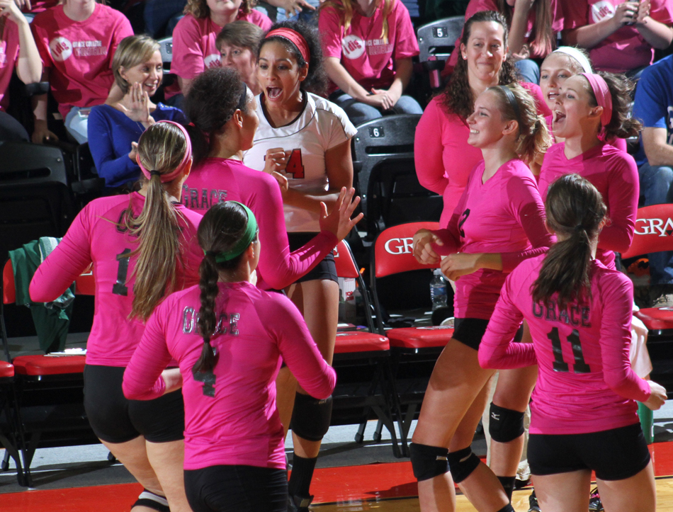 Grace College's women's volleyball team celebrates a point Friday night against Huntington.