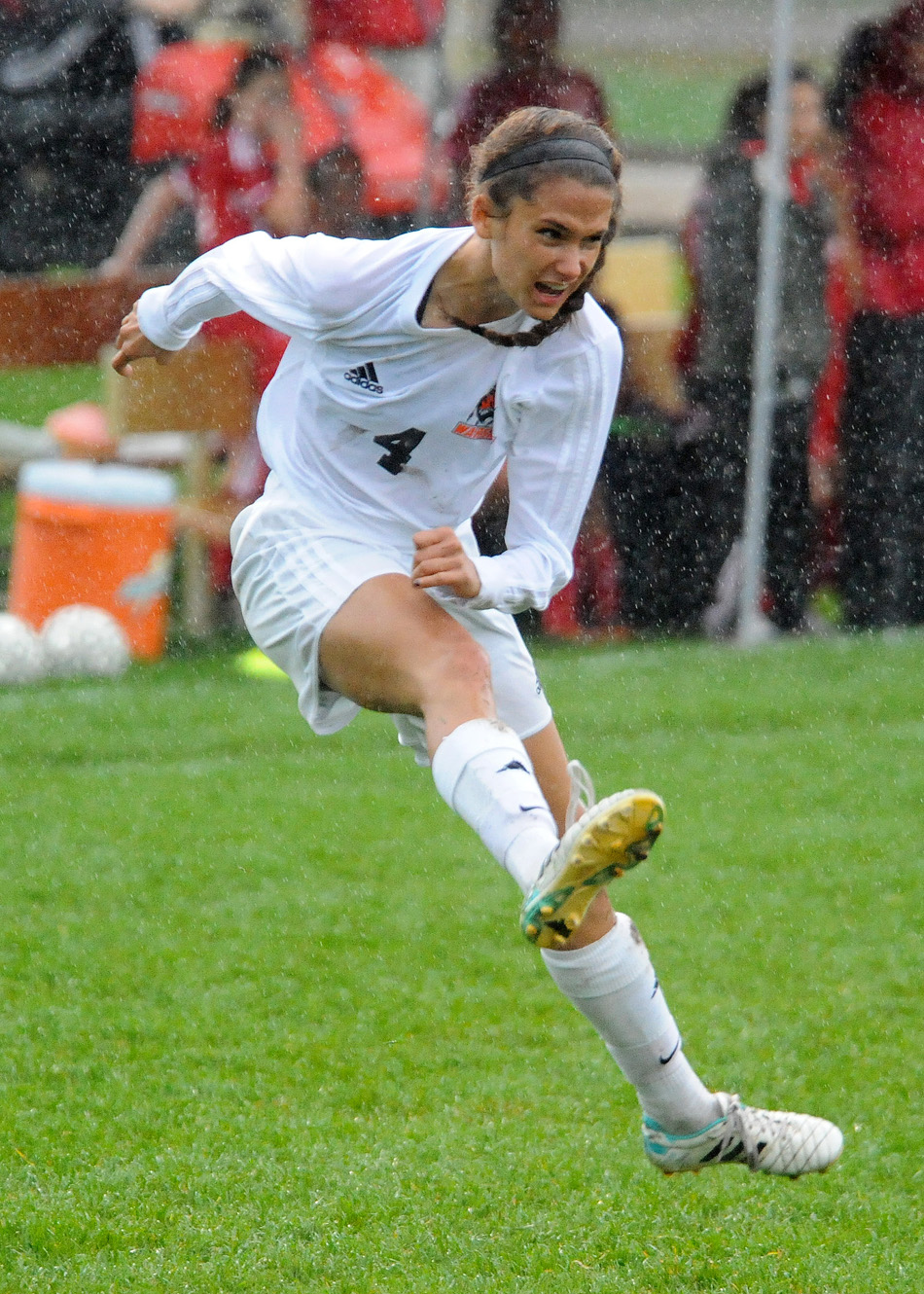 Warsaw's Clair Snodgrass sends in a cross during a heavy downpour in the first half of the semi-final match against Goshen at the Goshen Girls Soccer Regional.
