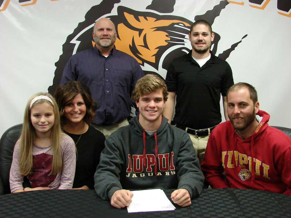 Warsaw Community High School senior Jayden Parrett, center, has signed a national letter of intent to continue his swim career at IUPUI. Seated with Jayden are Macelyn Marcuccilli, Jena Marcuccilli, Jayden Parrett and Michael Marcuccilli. In the back row are WCHS athletic director Dave Anson and WCHS boys swim coach Anthony DeBrota. (Photo provided by WCHS athletics)