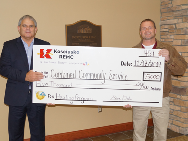 REMC President and CEO Bruce Goslee, presents a check to Executive Director Steve Possell of CCS.