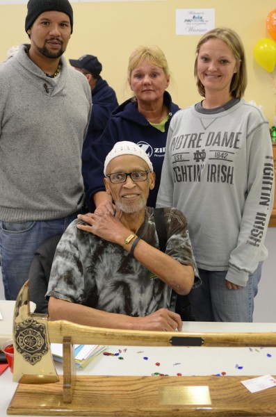 Mike Blair was honored with a surprise 67th birthday party today. He is shown with his son Tirean, his wife Cheryl, and daughter Cori. Blair received a golden ax as a birthday gift. (Photo by Deb Patterson)