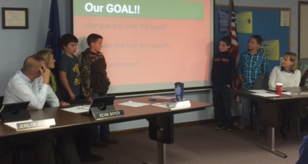 Triton School Board members Kevin Boyer, Amy Middaugh and Terri Barnhart are pictured as they listen to a presentation on "Operation Christmas Child" by Triton Elementary School fourth graders: Cory Hill, Cole Irvine, Keegan Best, and Landon Lemler. 