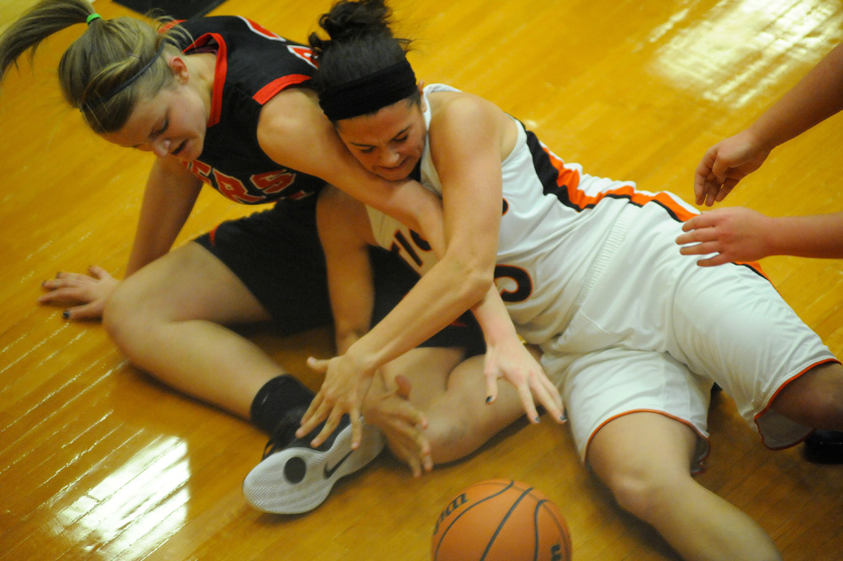Warsaw's Page Desenberg and Fort Wayne Luers' Kathryn Knapke battle for a loose ball.