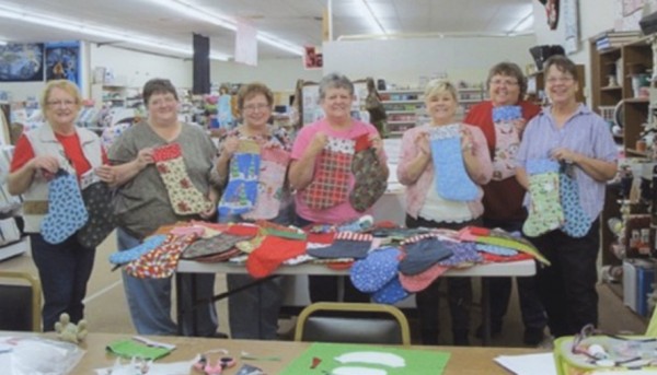 Pictured with some of the stockings, from left to right, are: Sue Earl, Kris Fry, Janet Reed, Sharon Richcreek, Molly Barth, Marsha Huffman and Warsaw American Legion Auxiliary unit 49 president Kathy Snell. (Photo provided)