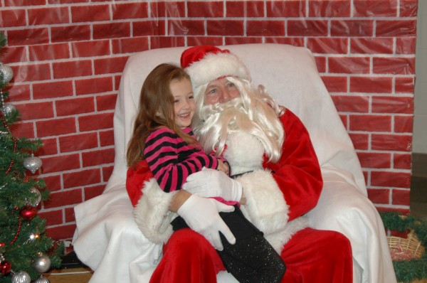 Ella Stewart, 5, sat on Santa’s lap at the Syracuse Community Center’s breakfast with Santa. After telling Santa what made it on her wish list this year, Stewart smiled shyly long enough for her mama to snap a cute photo, too.