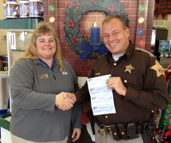 Cindy Renier presents a large donation to Chris McKeand, Kosciusko County FOP President, for the Christmas with a Cop Program. (Photo provided)